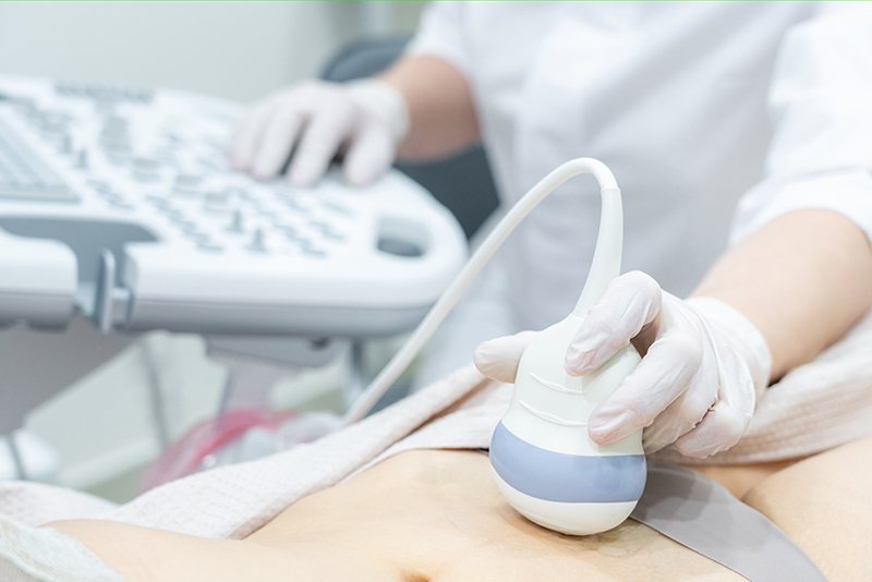 Gynecologist performing an ultrasound scan on a patient in a clinic.